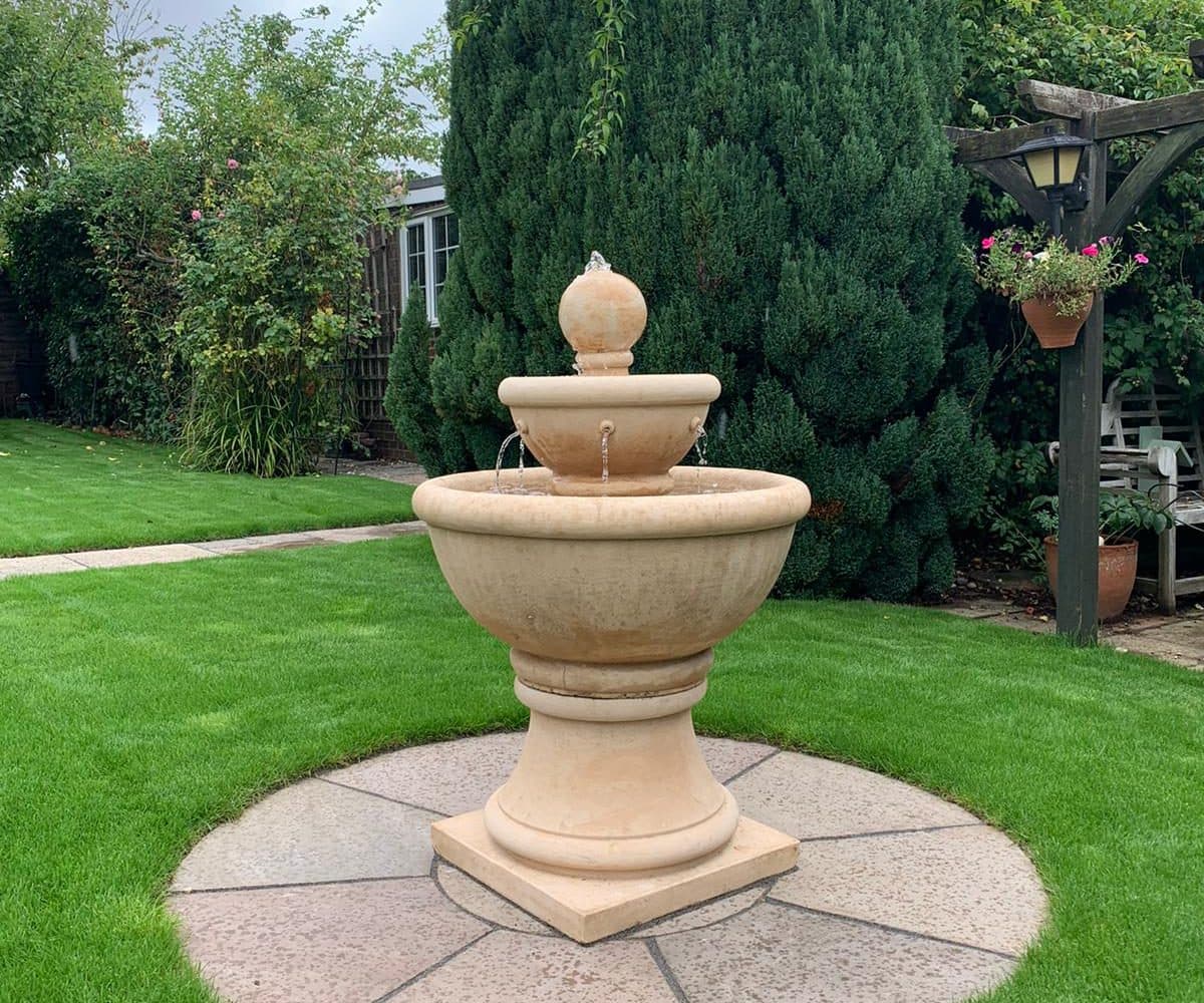 A compact self-contained stone fountain running on a patio