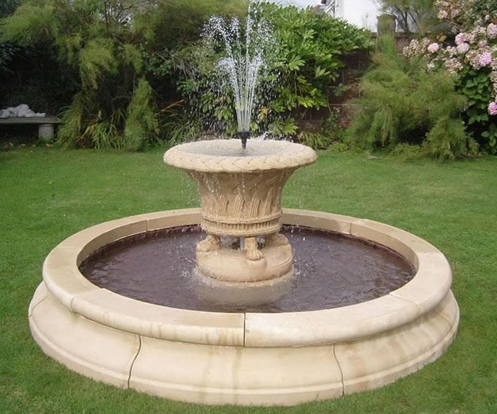 Close view of water falling between the tiers of a stone fountain